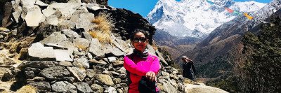 Manisha Koirala posing in hiking gear in front of Mount Everest.