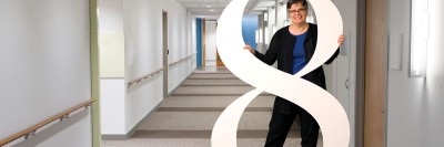 MSK director of social work Penny Damaskos, posing with a human-sized number 8